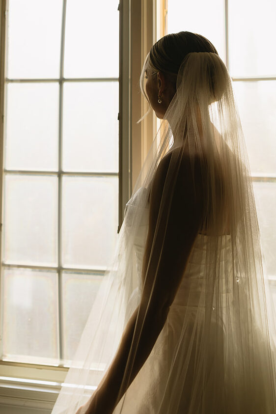bride getting ready for wedding looking out window