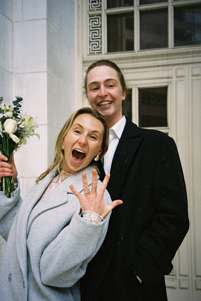 bride excitedly showing off her wedding ring for the camera