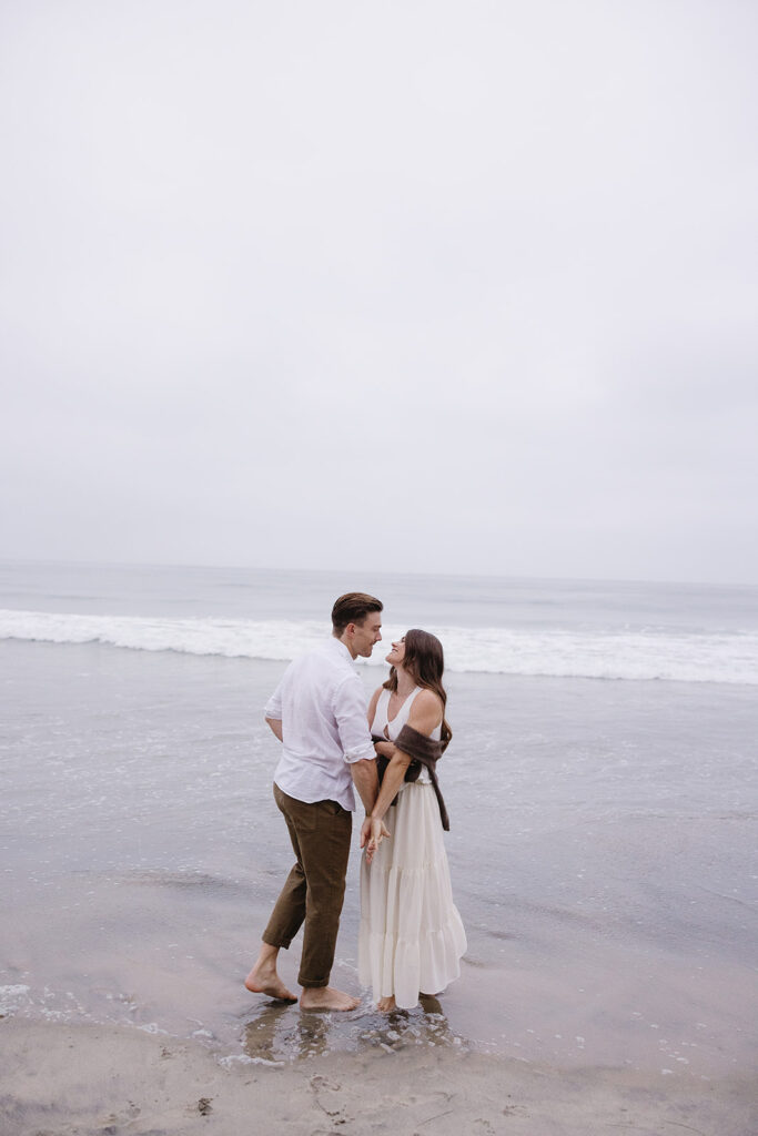 playful engagement photos on the beach at sunrise