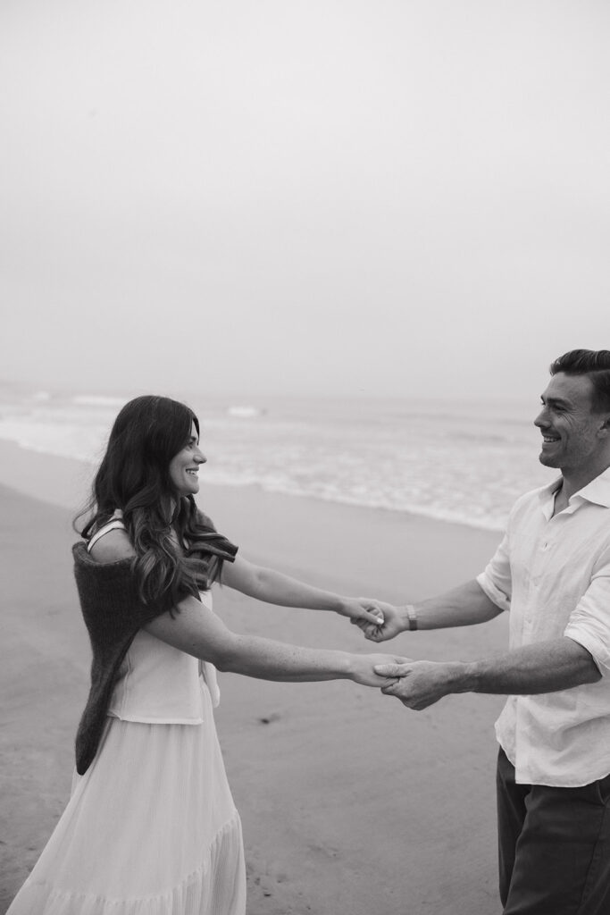 playful engagement photos on the beach at sunrise
