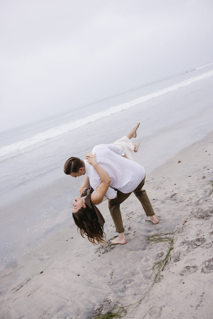 couple smiling and dancing on the beach