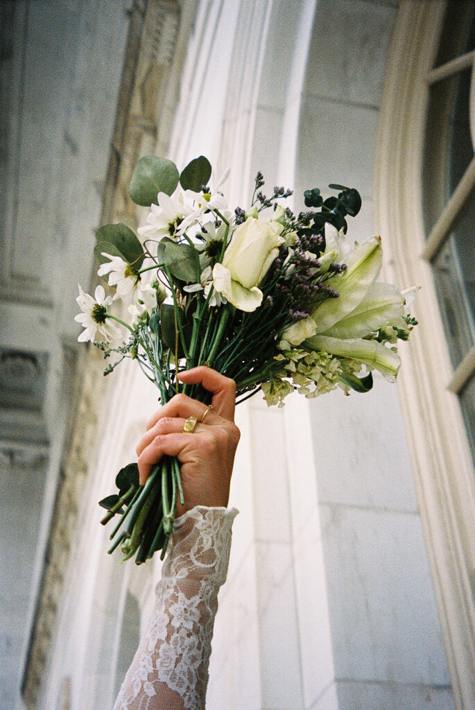 bride holding bouquet in the air film photography