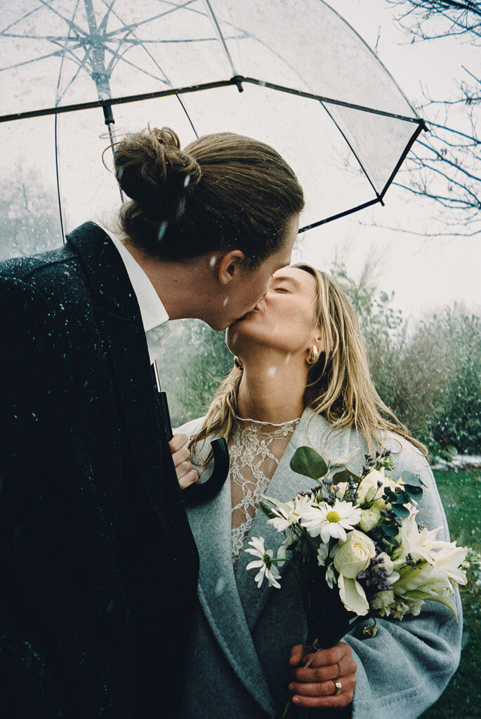 film photography of a couple walking down the street in the rain