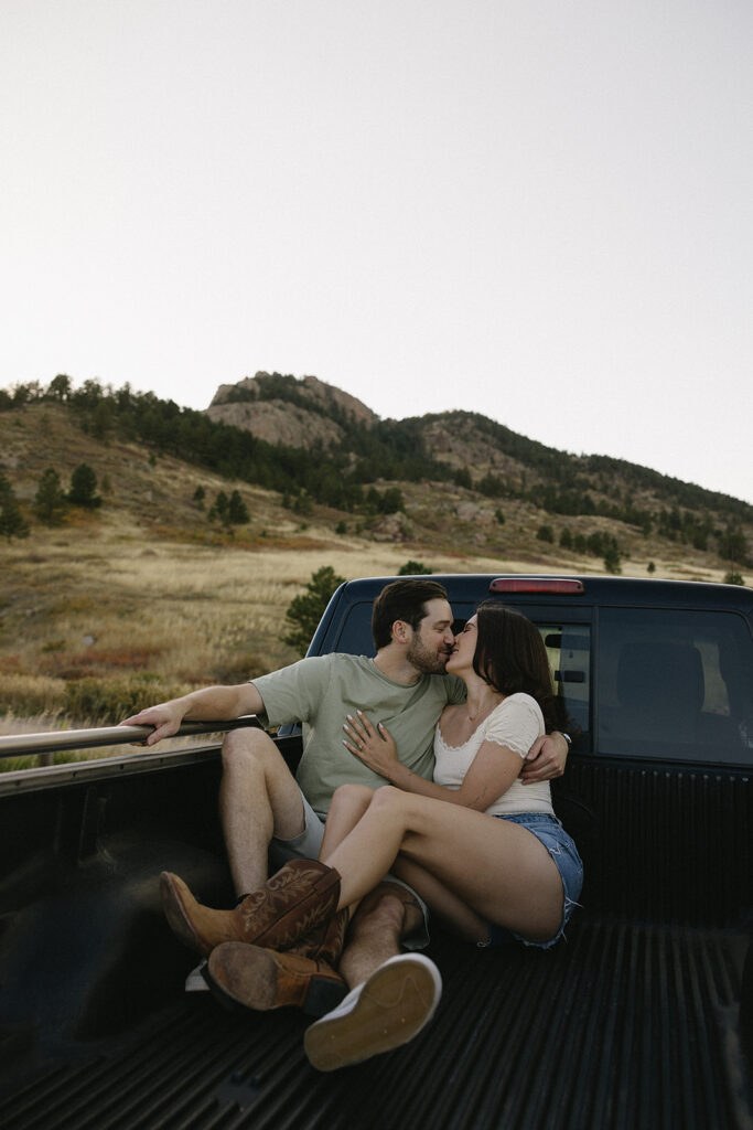western engagement photo in a truck bed in the mountains