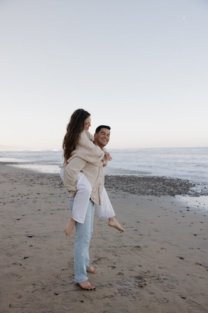 piggy back pose for a sunrise beach engagement photoshoot