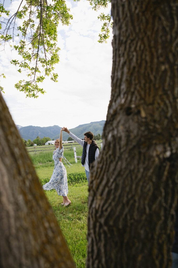 photo of couple spinning in between trees in utah