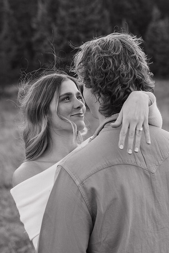 canid couple posing for engagement photos showing off wedding ring