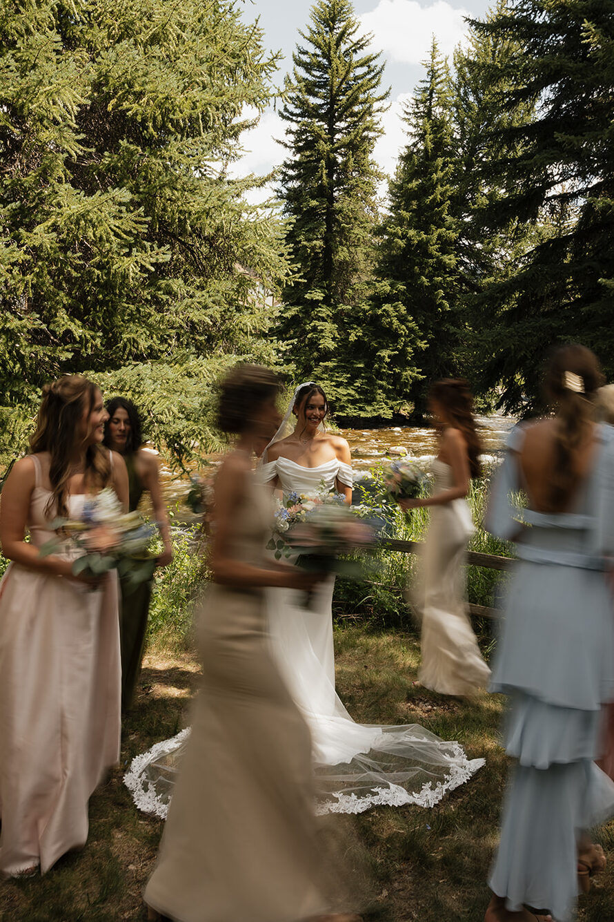 blurry bridesmaids photo walking around the bride in the mountains